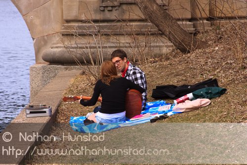 Two people play guitar and listen to the old vinyl near Lake of the Isles.